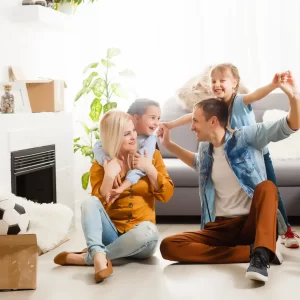 A family celebrating their fresh start in a bright, clutter-free living room, perfectly cleaned by Sparkclean Joy, using their move-in/out house cleaning services in McKinney